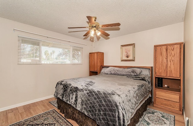 bedroom featuring hardwood / wood-style floors, a textured ceiling, and ceiling fan