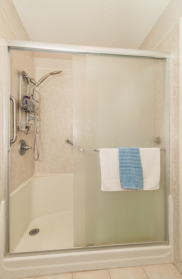 bathroom featuring tile patterned floors and a shower with shower door