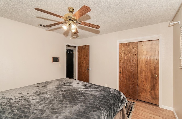 bedroom featuring a textured ceiling, ceiling fan, and a closet