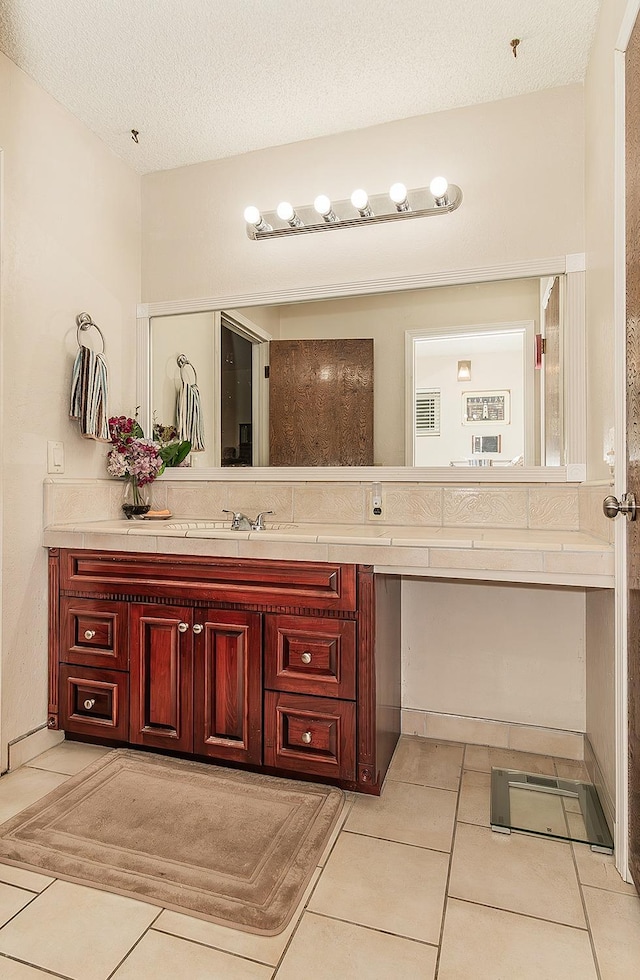 bathroom featuring vanity, tile patterned floors, and a textured ceiling