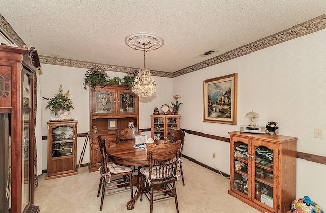 dining room featuring an inviting chandelier, light carpet, and a textured ceiling