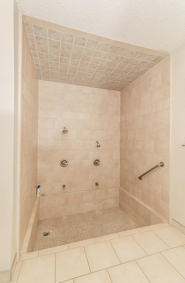 bathroom with a tile shower and tile patterned floors