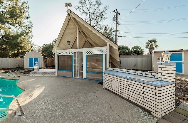 exterior space featuring a fenced in pool and a storage shed