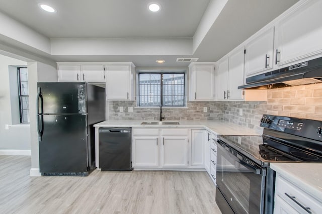 kitchen featuring white cabinetry, sink, decorative backsplash, light hardwood / wood-style floors, and black appliances