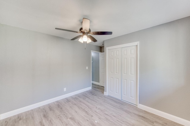 unfurnished bedroom featuring light hardwood / wood-style flooring, ceiling fan, and a closet