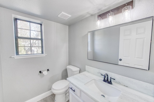 bathroom with vanity, hardwood / wood-style floors, a textured ceiling, and toilet