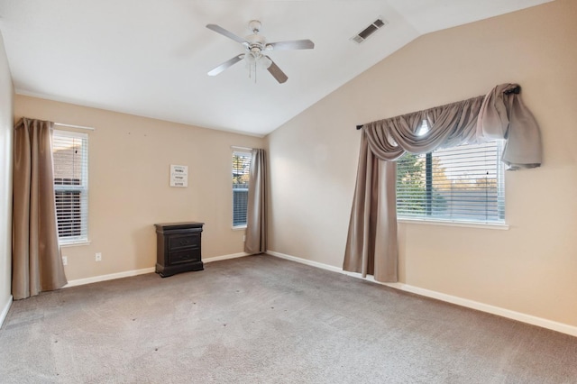 carpeted empty room featuring lofted ceiling, a wealth of natural light, and ceiling fan