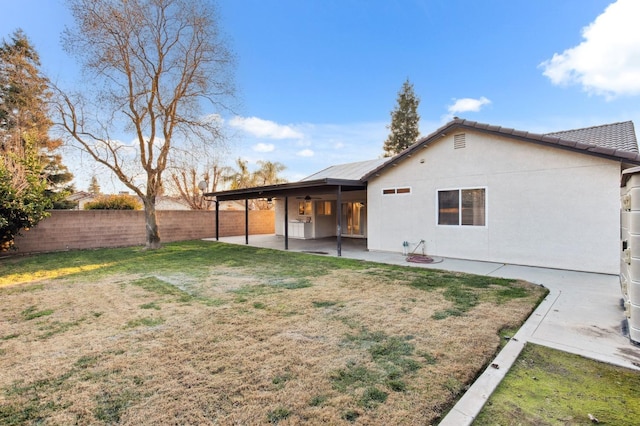 back of house featuring a lawn and a patio area