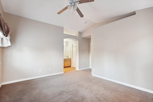 spare room featuring ceiling fan, lofted ceiling, and light carpet