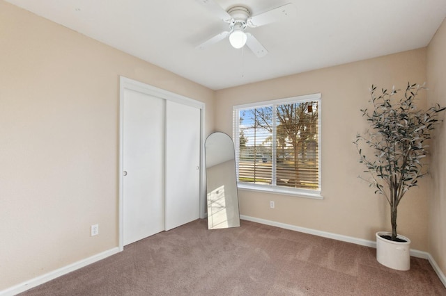 unfurnished bedroom with ceiling fan and carpet