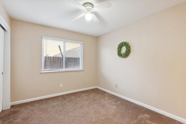 carpeted spare room with ceiling fan