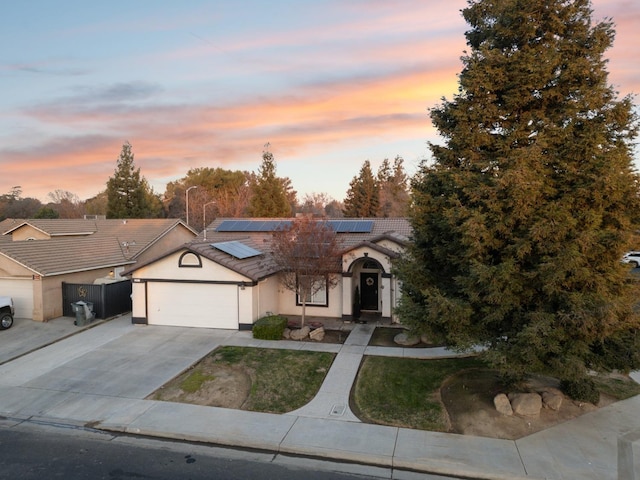 view of front of property featuring a garage and solar panels