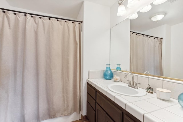 bathroom featuring vanity and backsplash