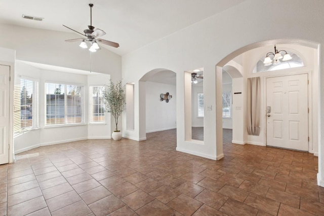 foyer entrance with ceiling fan with notable chandelier and vaulted ceiling