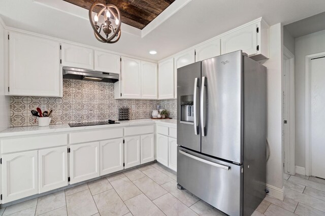 kitchen featuring white cabinets, black electric stovetop, wood ceiling, a tray ceiling, and stainless steel refrigerator with ice dispenser