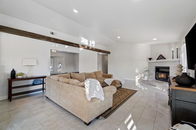 living room featuring vaulted ceiling, a fireplace, visible vents, and baseboards