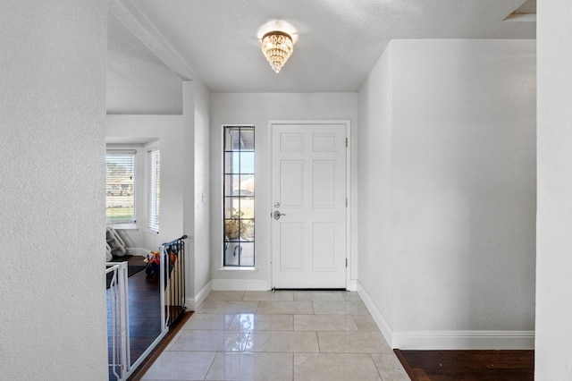 entrance foyer with baseboards and light tile patterned flooring