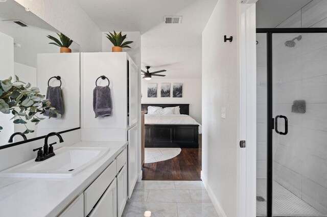 bathroom with tile patterned flooring, vanity, ceiling fan, and a shower with shower door