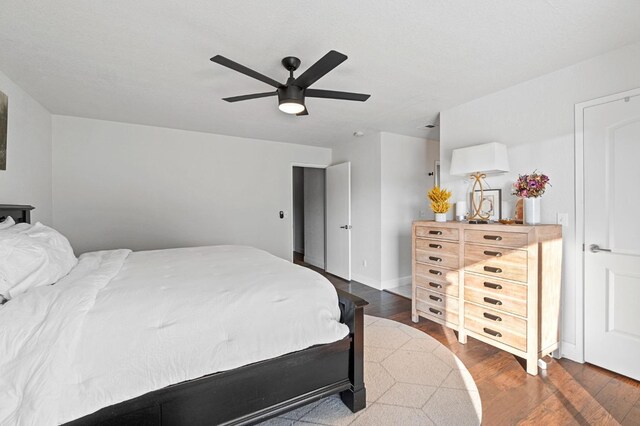 bedroom with dark hardwood / wood-style floors and ceiling fan