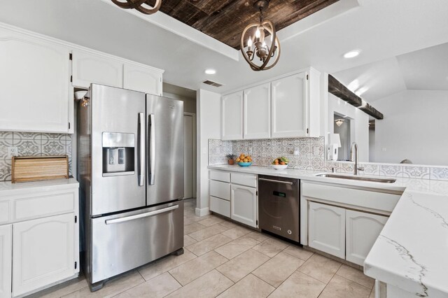 kitchen with appliances with stainless steel finishes, sink, white cabinets, and decorative backsplash