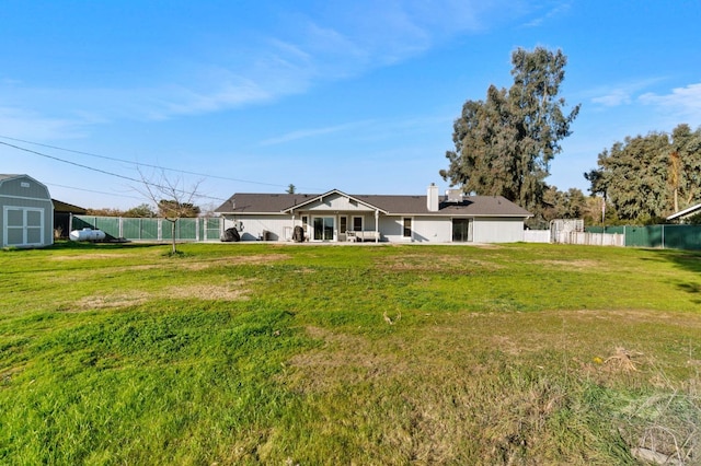 view of yard featuring a patio, a storage shed, an outdoor structure, and fence