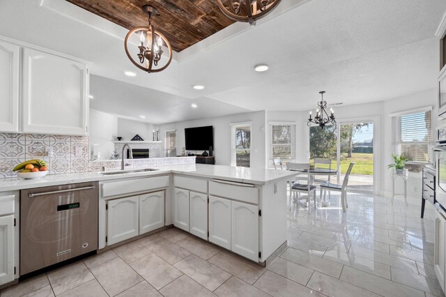 kitchen with an inviting chandelier, white cabinetry, appliances with stainless steel finishes, and sink