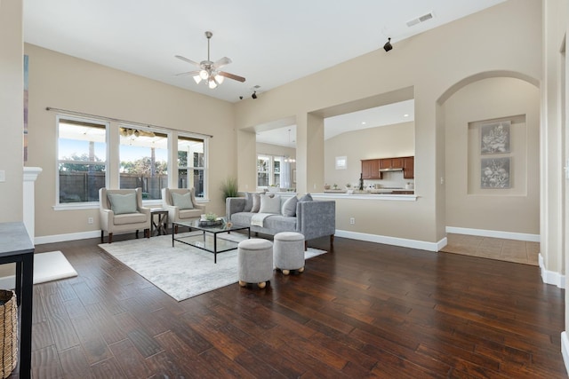 living room with dark wood-type flooring and ceiling fan