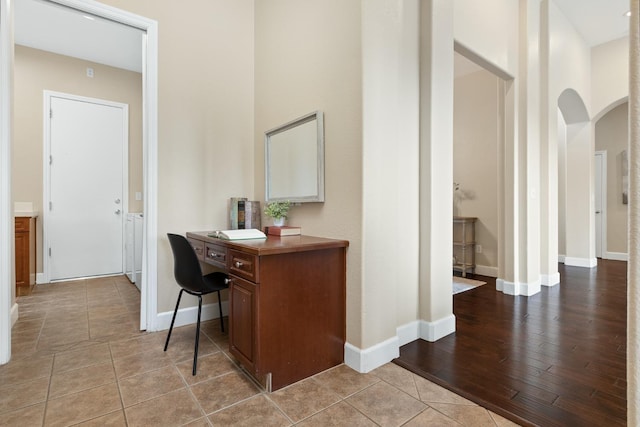 hallway with a high ceiling and light tile patterned floors