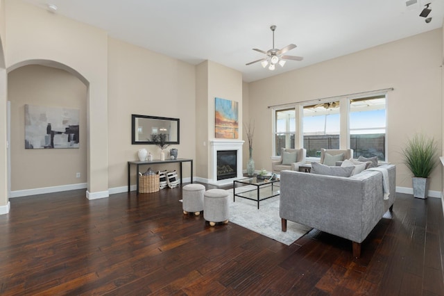 living room with dark wood-type flooring and ceiling fan