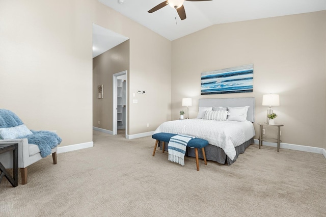 carpeted bedroom featuring ceiling fan, vaulted ceiling, and a walk in closet