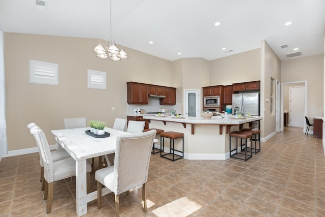 dining space with a towering ceiling and an inviting chandelier