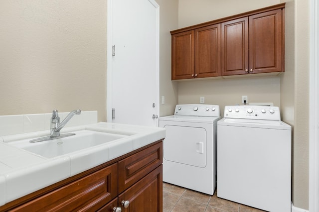 clothes washing area featuring light tile patterned flooring, cabinets, separate washer and dryer, and sink