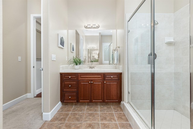 bathroom featuring a shower with door, vanity, and tile patterned flooring