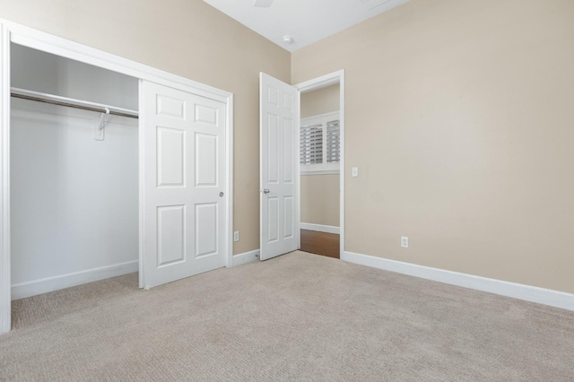 unfurnished bedroom featuring light colored carpet and a closet