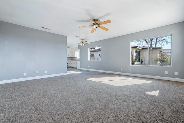 unfurnished living room with ceiling fan and carpet