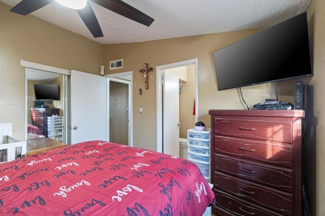 bedroom with ceiling fan, ensuite bath, lofted ceiling, and a textured ceiling