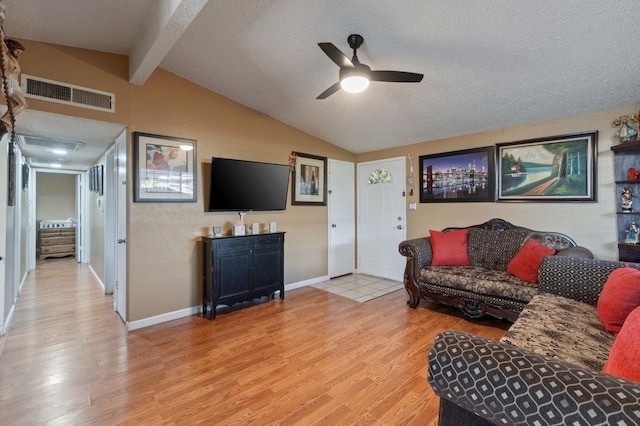 living room with vaulted ceiling with beams, light hardwood / wood-style floors, a textured ceiling, and ceiling fan