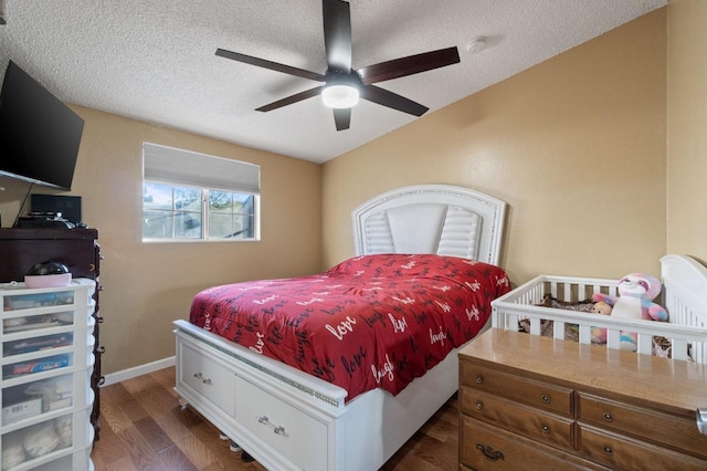 bedroom featuring ceiling fan, a textured ceiling, and dark hardwood / wood-style flooring