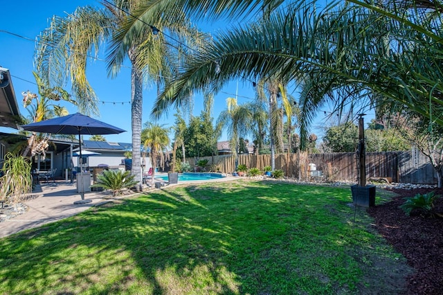 view of yard featuring a fenced in pool, a fenced backyard, and a patio