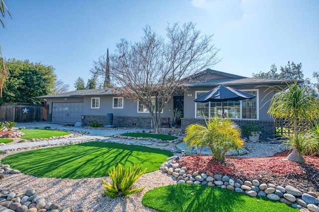 ranch-style house with brick siding, fence, an attached garage, and stucco siding