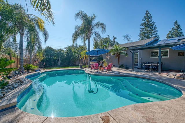 view of pool with a patio area, fence, a fenced in pool, and outdoor dining space