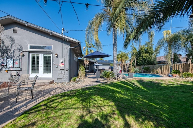 view of yard featuring a patio, french doors, a fenced backyard, and a fenced in pool