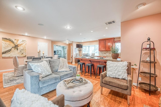 living area featuring light wood-type flooring and baseboards