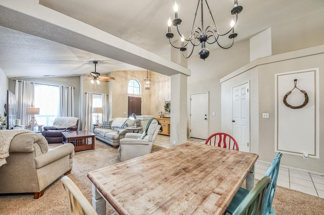 dining area featuring vaulted ceiling, ceiling fan with notable chandelier, light tile patterned flooring, and a textured ceiling