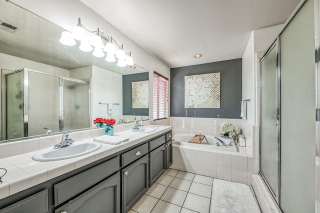 bathroom featuring tile patterned flooring, visible vents, a sink, and a bath