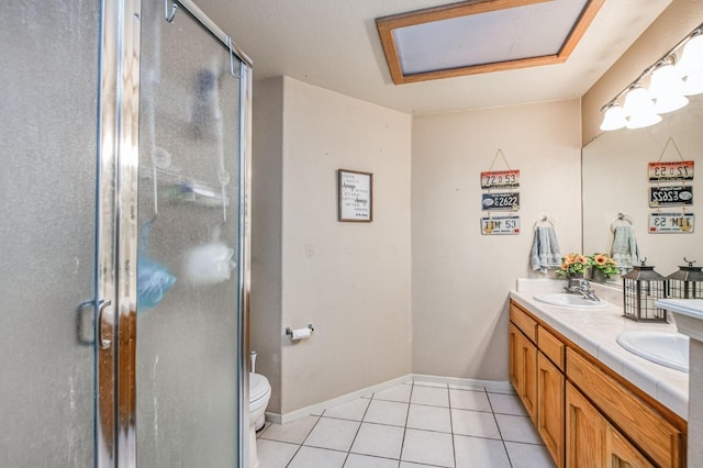 full bathroom featuring double vanity, a stall shower, toilet, tile patterned floors, and a sink