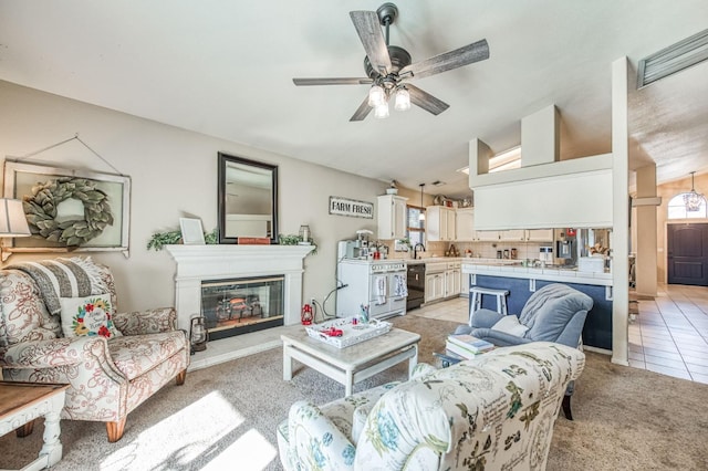 living area featuring lofted ceiling, light carpet, plenty of natural light, and light tile patterned flooring