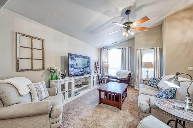 living area featuring visible vents, ceiling fan, carpet, vaulted ceiling, and a textured ceiling