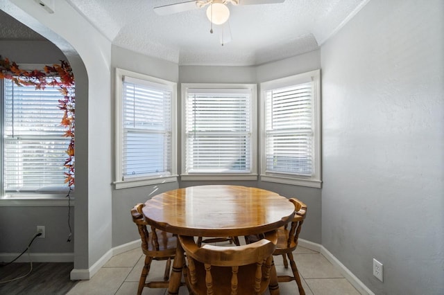 dining space featuring ceiling fan, tile patterned flooring, and a textured ceiling