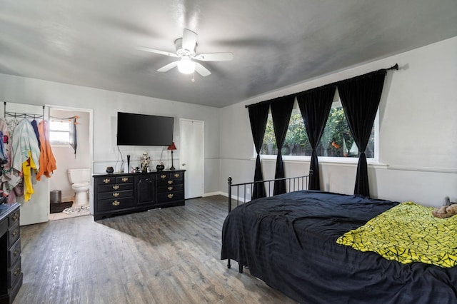 bedroom featuring multiple windows, hardwood / wood-style flooring, connected bathroom, and ceiling fan